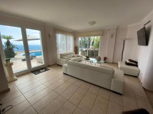 コンブレ・デル・ソルにあるVilla Jannineの白い家具付きのリビングルームが備わり、海の景色を望めます。