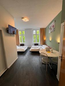 ein Zimmer mit zwei Betten und einem Tisch und Stühlen in der Unterkunft Stadtoase im Herzen Berlins in Berlin