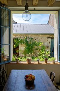 uma taça de fruta numa mesa em frente a uma janela em La Bicyclette em Chisseaux