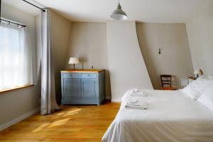 1 dormitorio con 1 cama blanca y armario azul en La Bicyclette, en Chisseaux