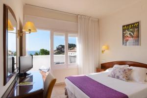 a hotel room with a bed and a window at RVHotels Avenida in Tossa de Mar