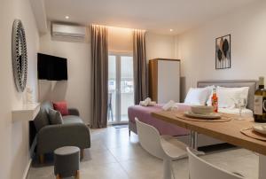 a bedroom and living room with a bed and a table at KA Luxury Apartments in Mantoúkion