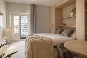 a bedroom with a bed and a table in a room at Líbere Bilbao Ledesma in Bilbao