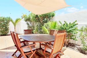 a wooden table with chairs and an umbrella on a patio at Casa Tauro in Adeje