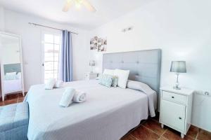 阿德赫的住宿－Casa Tauro，卧室配有带毛巾的大型白色床