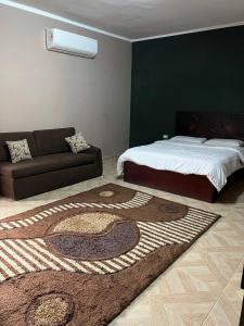 a bedroom with a bed and a couch and a rug at Aoda pyramids in Cairo