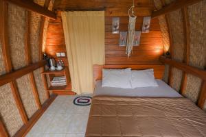 a bedroom with a bed in a wooden cabin at Volcano Cabin Batur RedPartner in Baturaja