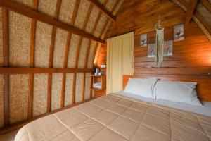 1 dormitorio con 1 cama en una habitación de madera en Volcano Cabin Batur RedPartner en Baturaja
