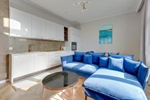 un soggiorno con divano blu e tavolo di Dom & House - Apartament Kościuszki Family a Sopot
