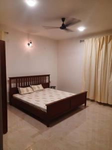 a bedroom with a bed and a ceiling fan at The RusticVibe-Villa with Garden 30 km frm Ecity in Bangalore