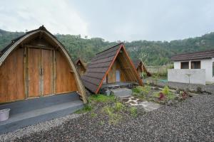 a group of wooden huts in a yard at Volcano Cabin Batur RedPartner in Baturaja