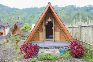 una pequeña casa con una puerta en un patio en Volcano Cabin Batur RedPartner, en Baturaja