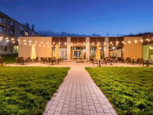 a building with tables and chairs at night at Mercure Karpacz Skalny in Karpacz