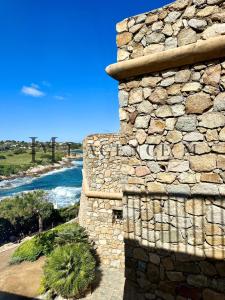 una pared de piedra con un río en el fondo en Maison de village typique bord de mer en Algajola