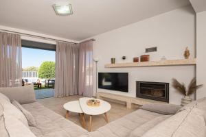 a living room with a couch and a fireplace at Villa Serenity in Ialyssos