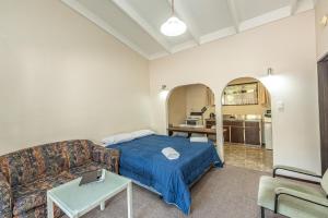 uma sala de estar com uma cama e um sofá em Riverside Motel em Whanganui