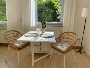 een witte eettafel met 2 stoelen en een raam bij Fremdenzimmer Kallenbachtal in Löhnberg