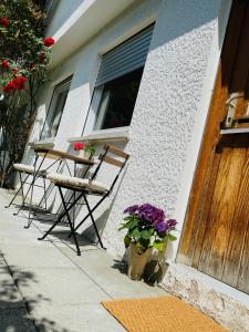 een tafel en stoelen buiten een huis met bloemen bij Fremdenzimmer Kallenbachtal in Löhnberg