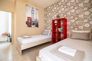 a bedroom with two beds and a red cabinet at Villa Serenity in Ialyssos +34 photos