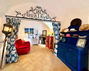 Maison de village typique bord de mer في ألغاجولا: غرفة معيشة مع أريكة حمراء وكرسي احمر