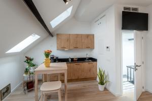 a kitchen with wooden cabinets and a table and chairs at Miniloft Pelgrim in Antwerp