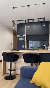 a kitchen with two black chairs and a kitchen island at Apartament Poleska in Częstochowa