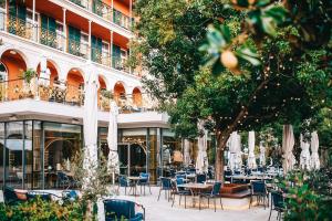 an outdoor cafe with tables and chairs and umbrellas at Hilton Imperial Dubrovnik in Dubrovnik