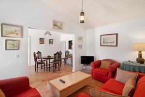 ein Wohnzimmer mit einem roten Sofa und einem Tisch in der Unterkunft Quinta de Loubite - Laranjeiras in Lagoa