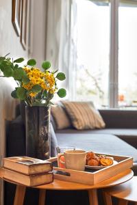 a coffee table with a tray of food and a vase with flowers at BBarcelona Gracia Flat in Barcelona