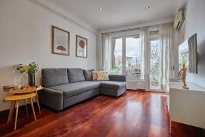 een woonkamer met een bank en een tafel bij BBarcelona Gracia Flat in Barcelona