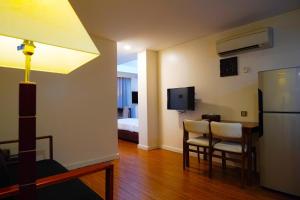 a room with a kitchen with a table and a refrigerator at Hotel KBA in Yangon