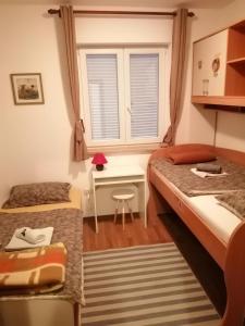 ロヴィニにあるApartman Morenoのベッドルーム1室(ベッド2台、デスク、窓付)