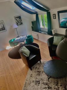 uma sala de estar com cadeiras, um sofá e uma mesa em Charmant gîte avec extérieur et piscine partagée em Mespaul