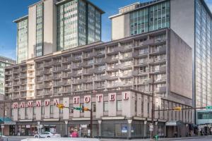 a large building with a sign on the side of it at Ramada Plaza by Wyndham Calgary Downtown in Calgary