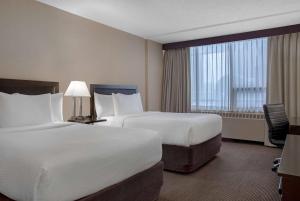 Postel nebo postele na pokoji v ubytování Ramada Plaza by Wyndham Calgary Downtown