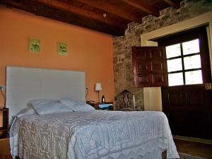 a bedroom with a bed in a room with a window at Casa Rural A Pasada in Cedeira