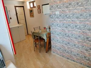 een eetkamer met een tafel en een bakstenen muur bij Hospedaje Senda del Huerna in Campomanes