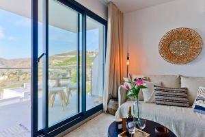 a living room with a couch and a large glass window at Casa Grace in Nerja