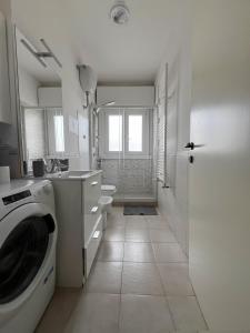 y baño blanco con lavadora. en Atlantico Apartment en Roma