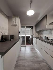 a large kitchen with white cabinets and a tile floor at Atlantico Apartment in Rome