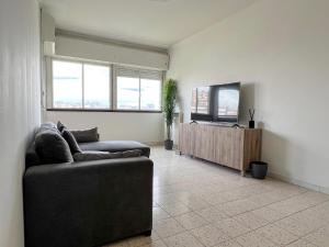 uma sala de estar com um sofá e uma televisão em Atlantico Apartment em Roma