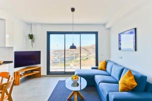 een woonkamer met een blauwe bank en een groot raam bij Balcon del Mar in Nerja