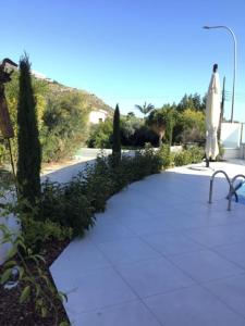 un passaggio pedonale con panchina e ombrellone di Katikies Superior Villa a Pissouri