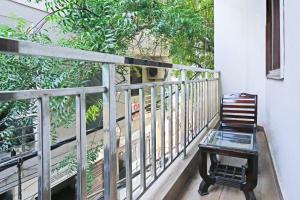 een stoel en een glazen tafel op een balkon bij Hotel Red Stone Mahipalpur in New Delhi