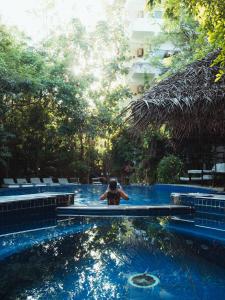 a person sitting in a pool in a swimming pool at Sundaras Resort & Spa Dambulla in Dambulla