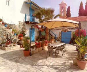 a table and chairs under an umbrella on a patio at Traditional House in Pera in Pera
