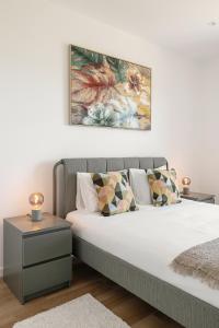 um quarto com uma cama com duas mesas e um quadro na parede em Pérola Lux Villa no Vau