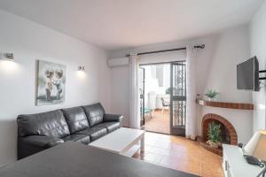 ein Wohnzimmer mit einem Sofa und einem Kamin in der Unterkunft 19C Las Palmas Oasis de Capistrano in Nerja