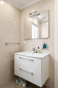 een badkamer met een witte wastafel en een spiegel bij Morasol 6-4 in Nerja