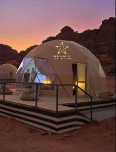 une grande tente en forme de dôme dans le désert au coucher du soleil dans l'établissement RUM SUNRlSE LUXURY CAMP, à Wadi Rum